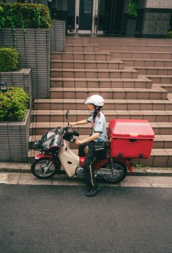 a person on a motor scooter with a cooler on the back